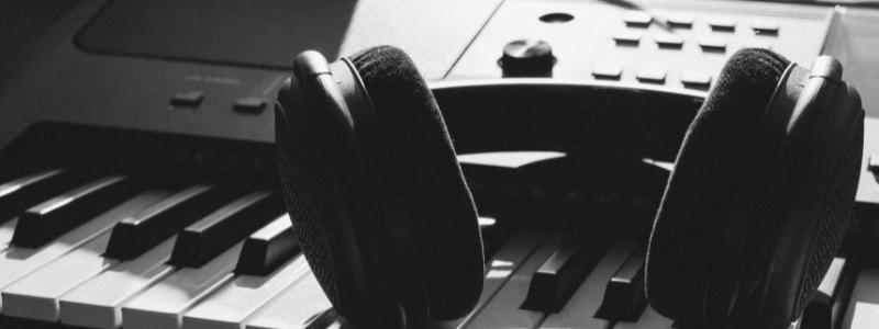 A photo with headphones on a piano
