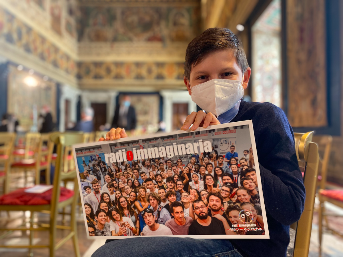 Marco, speaker di San Giovanni in Persiceto, tiene in mano una foto che rappresenta tutti gli speaker di Radioimmaginaria mentre è all'interno del Quirinale in attesa di incontrare il Presidente Mattarella