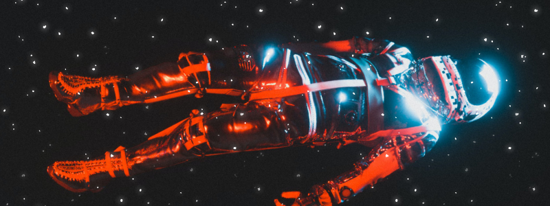 Un'astronauta in una tuta illuminata da delle luci rosse e blu fluttua tra le stelle disteso come se fosse morto