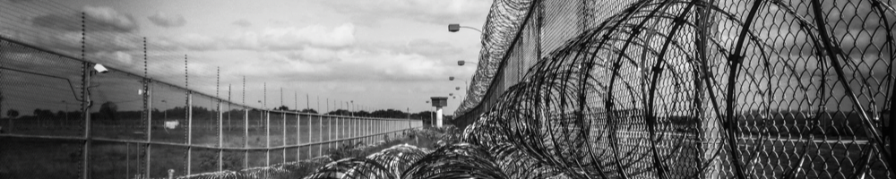 Foto dell’esterno di una prigione con una rete di filo spinato