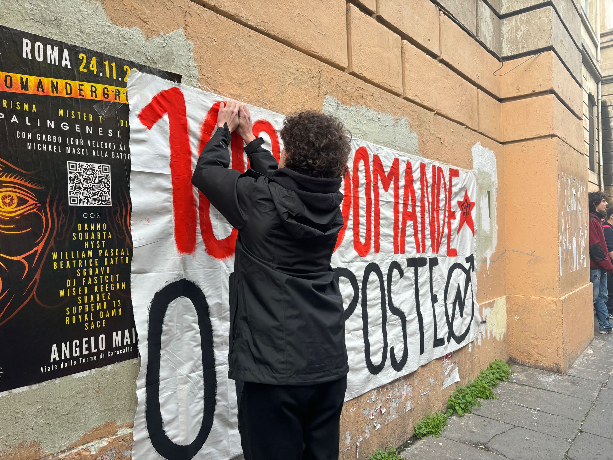 Striscione appeso alla facciata del Liceo Tasso di Roma con sopra scritto "1000 domande 0 risposte"